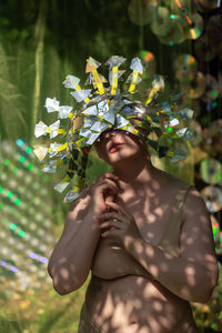 Portrait a woman in a reflective mask in a beige bikini on a cd / dvd case of scenery in the forest