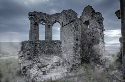 Old ruins against sea during sunset