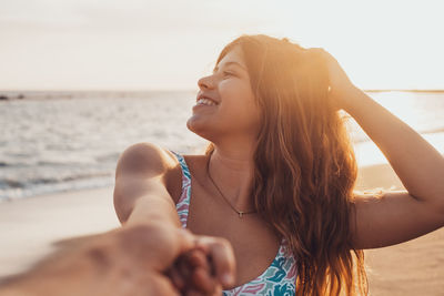 Side view of young woman looking away against sea