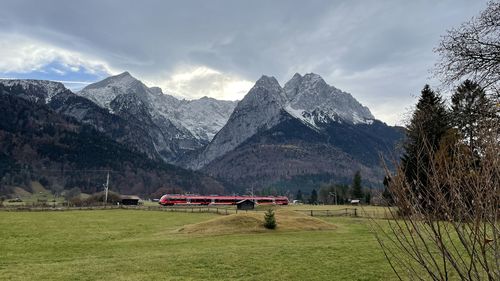 Scenic view of field and mountains against sky garmisch-partenkirchen