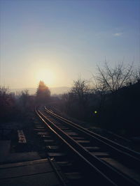 Railroad tracks against sky during sunset