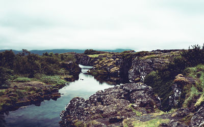 Scenic view of river amidst rocks against sky