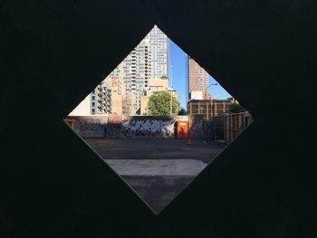 Buildings in city seen through diamond shaped window