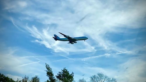 Low angle view of airplane flying against sky