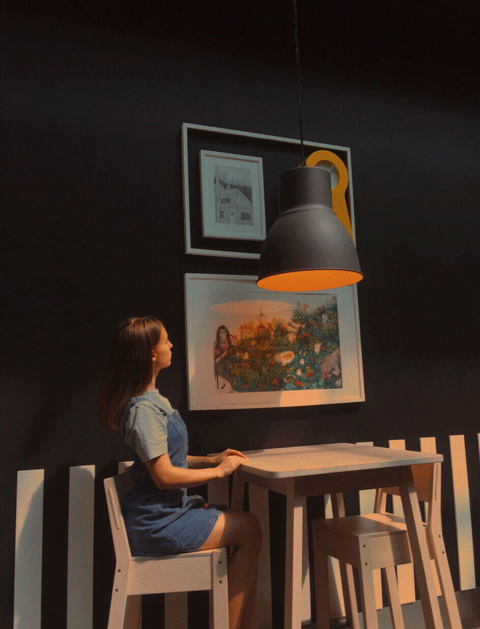 SIDE VIEW OF WOMAN SITTING ON CHAIR IN TABLE