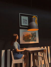 Side view of woman sitting on chair