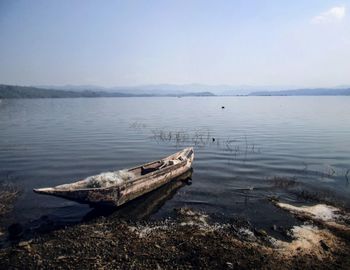 Abandoned boat on beach against sky