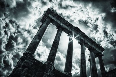 Low angle view of abandoned building against cloudy sky