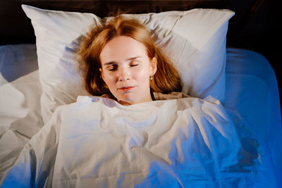 Young woman sleeping on bed