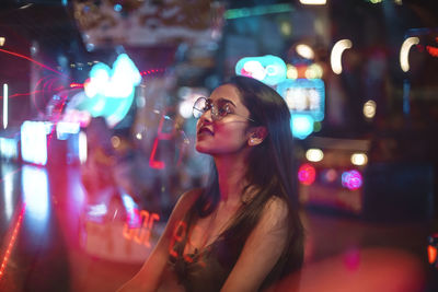 Portrait of smiling young woman at night