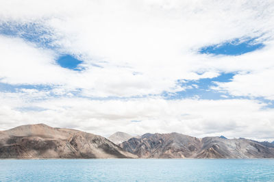 Calm lake against rocky mountains