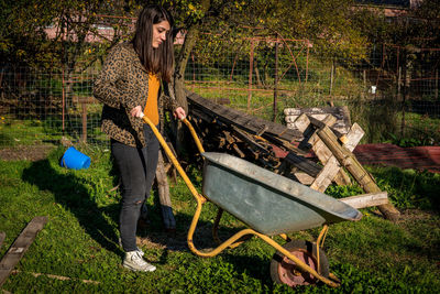 Young woman with umbrella on plants in yard