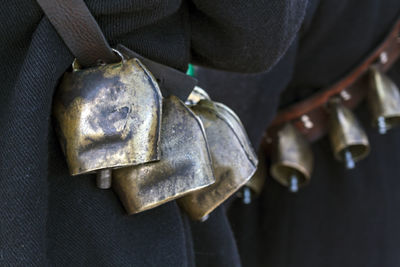 Close-up of man holding camera hanging on metal