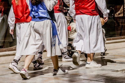 Low section of women walking on road