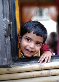 Portrait of smiling girl looking through bus window