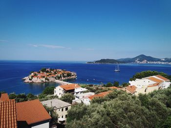 High angle view of townscape by sea against sky