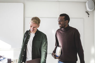 Smiling young male students in university classroom