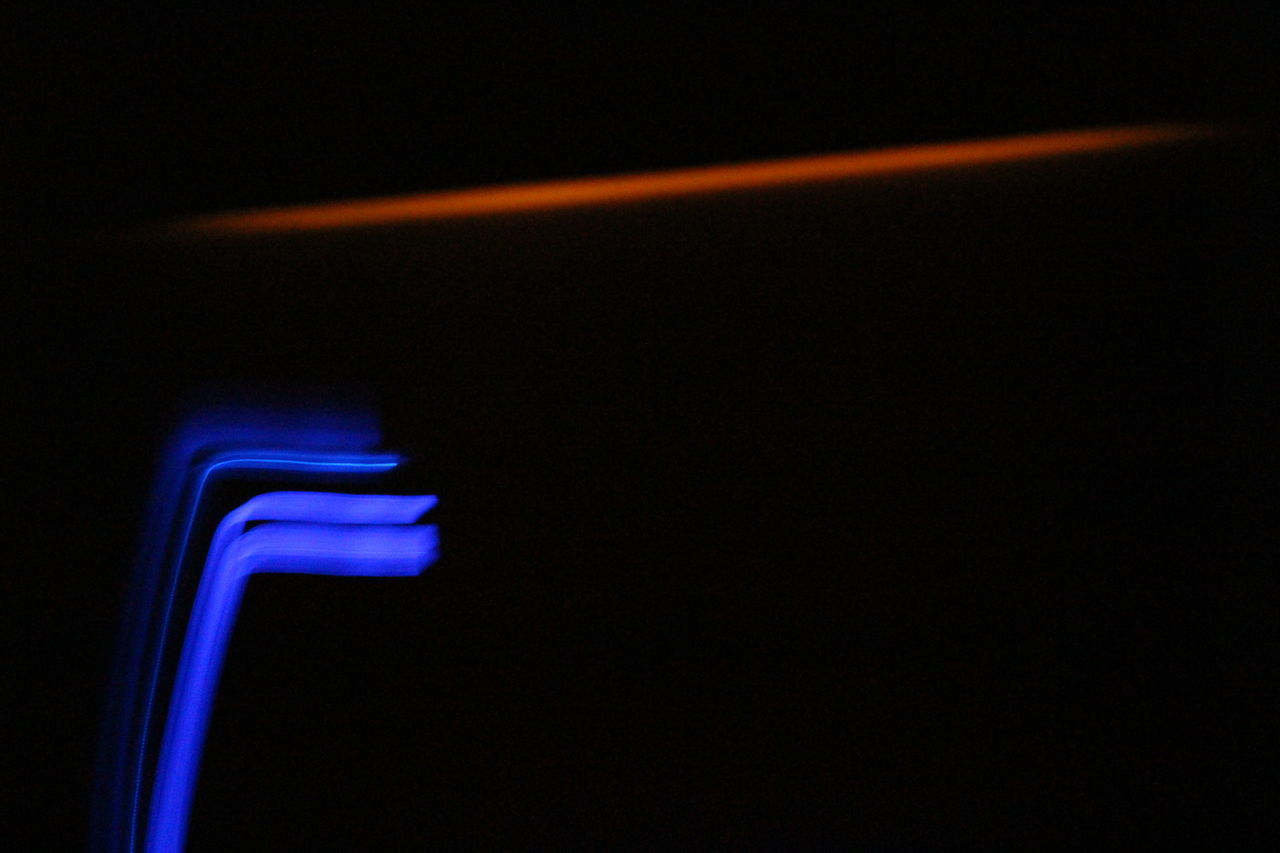 CLOSE-UP OF ILLUMINATED LIGHT ON BLACK BACKGROUND