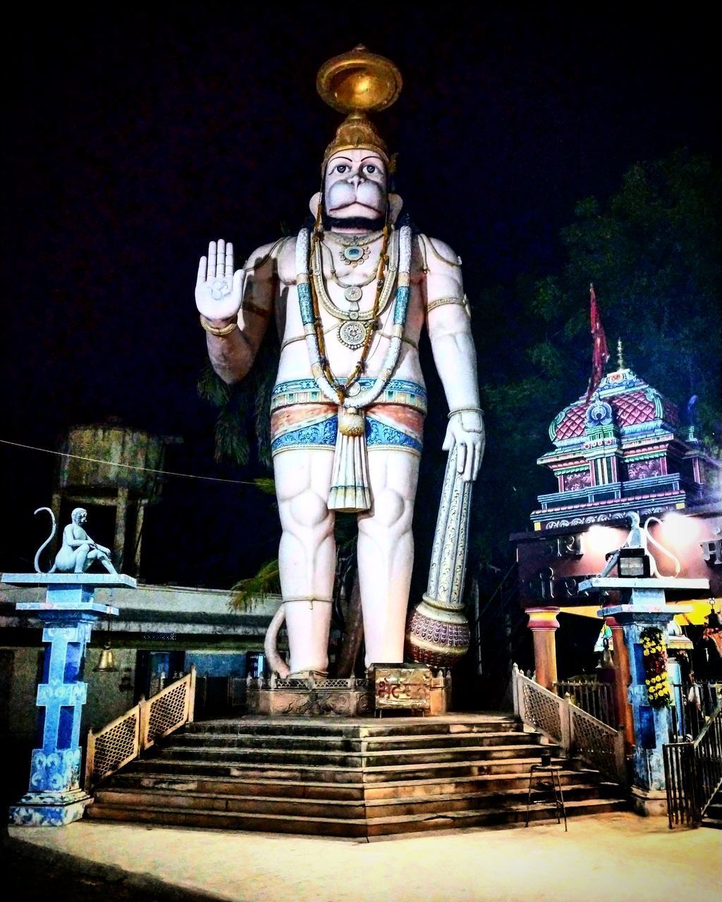 STATUE OF ILLUMINATED TEMPLE OUTSIDE BUILDING AT NIGHT