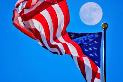 Low angle view of flag against blue sky