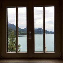 View of frozen lake seen through window