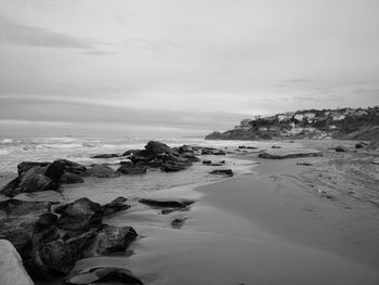 Scenic view of rocks on beach against sky