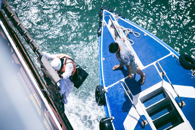 High angle view of man climbing on ship in sea