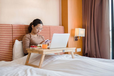 Young woman using laptop at home