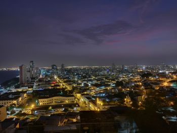 High angle view of illuminated city against sky at night