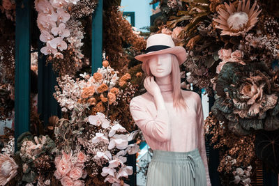 Midsection of woman standing by flowering plants