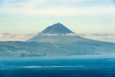 Scenic view of sea and mountains against sky