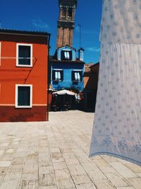 View of clothesline next to houses against cloudy sky