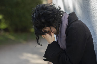 Side view of woman looking at camera