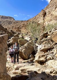 People walking on rocks against mountains