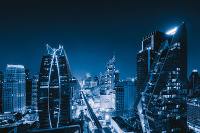 Illuminated buildings in city against sky at night