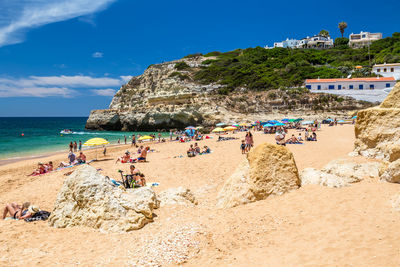 People at beach against sky