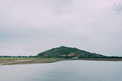 Scenic view of land and mountains against sky
