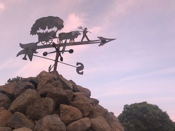 Low angle view of weather vane against sky