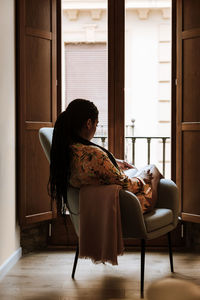 Ethnic woman with book resting at home