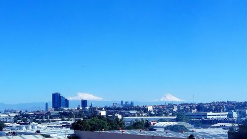 View of cityscape against blue sky