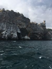 Rock formations by sea against sky