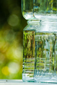 Close-up of glass jars stacks on table at back yard
