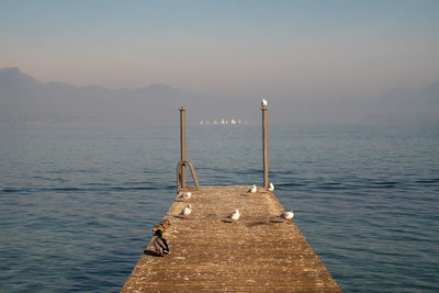 Pier over sea against sky during sunset