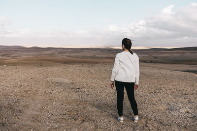 Rear view of woman standing on field