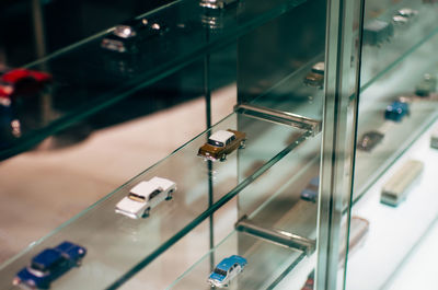 Miniature cars on glass shelf