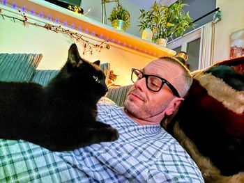 Midsection of man with cat resting on floor