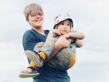 Portrait of happy friends against sky