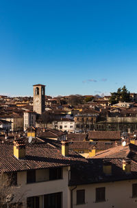 Aerial view of townscape against blue sky