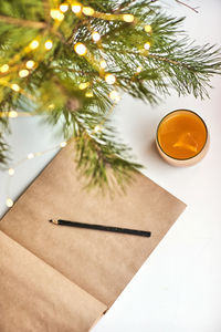 High angle view of christmas tree on table with notepad and pensil