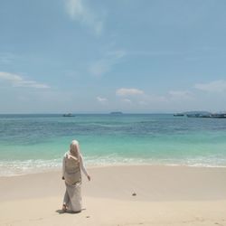 Rear view of woman looking at sea against sky